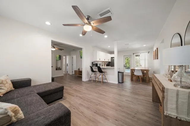 a living room with furniture and a wooden floor