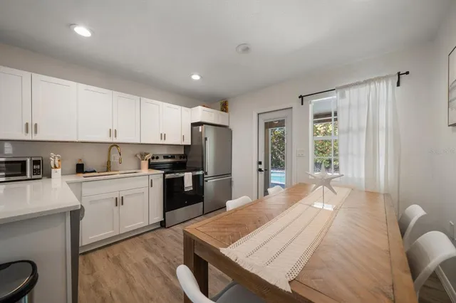 a view of kitchen with kitchen island a stove a sink and a refrigerator