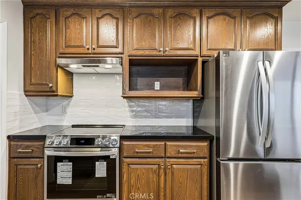 a kitchen with granite countertop stainless steel appliances and wooden cabinets