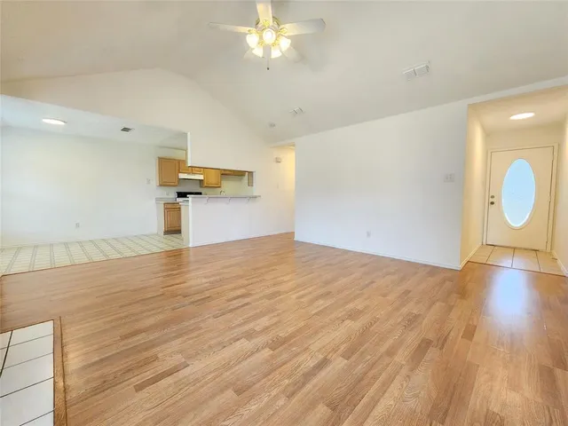 a view of empty room with wooden floor and fireplace