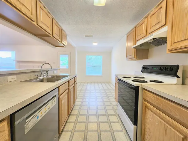 a kitchen with a sink stove top oven and cabinets