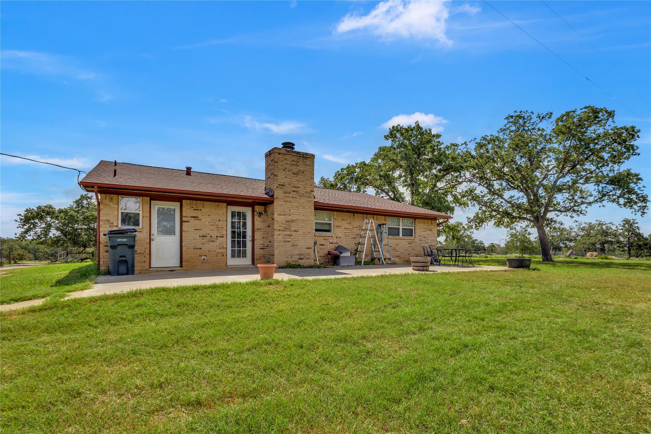1080 League Line Road Paige, TX 78659 - Photo 24 of 39 An expansive grassy yard surrounds the classic brick exterior and rear concrete patio.