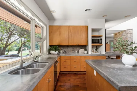 a kitchen with a sink a counter top space and cabinets