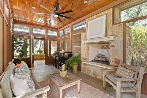 a living room with furniture a table and large windows