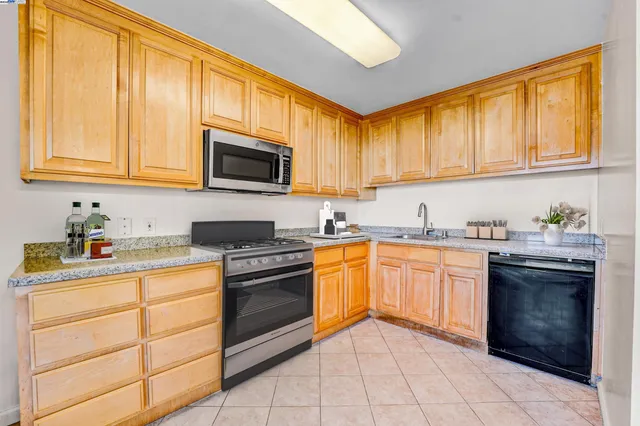 a kitchen with stainless steel appliances granite countertop a stove sink and cabinets