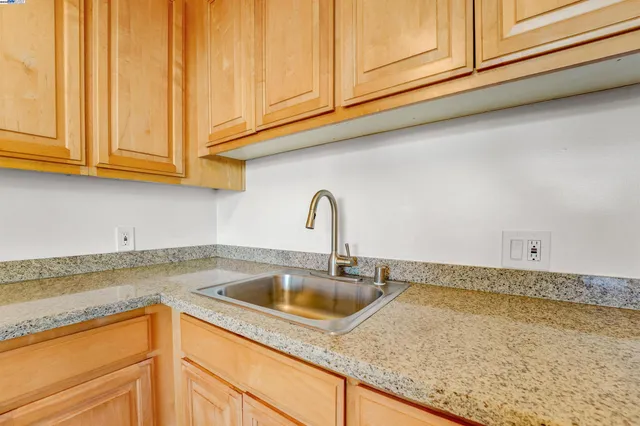a kitchen with granite countertop a sink and cabinets