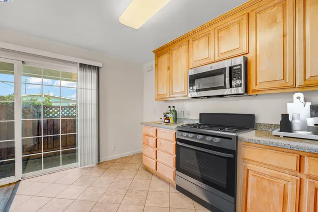 a kitchen with granite countertop a stove top oven cabinetry a sink and a microwave