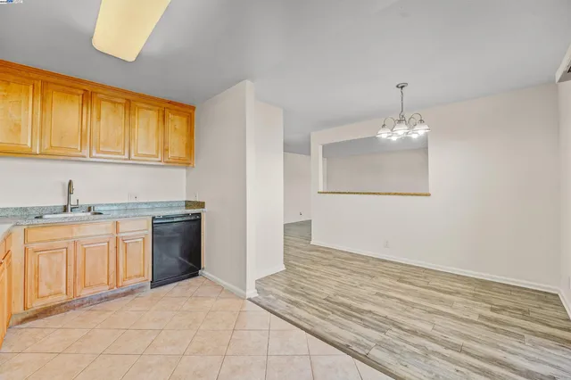 a kitchen with stainless steel appliances granite countertop a sink and cabinets with wooden floor
