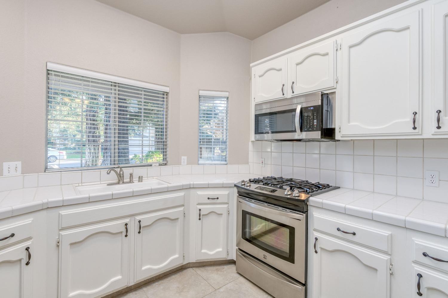 2365 Fallbrook Avenue Clovis, CA 93611 - Photo 16 of 42 a kitchen with white cabinets appliances and a window