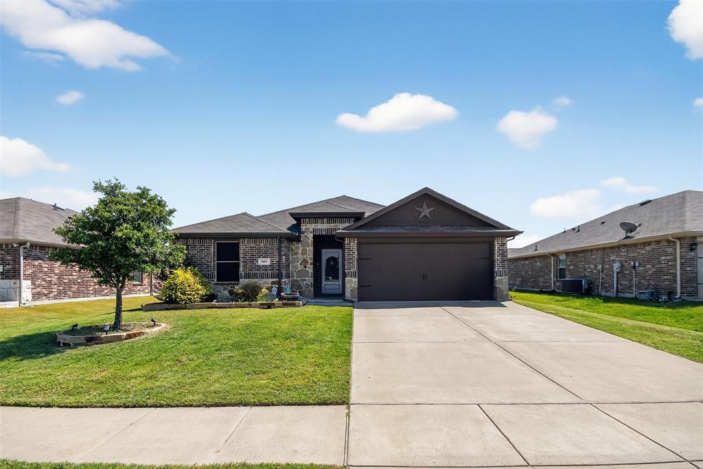 a front view of house with yard and garage