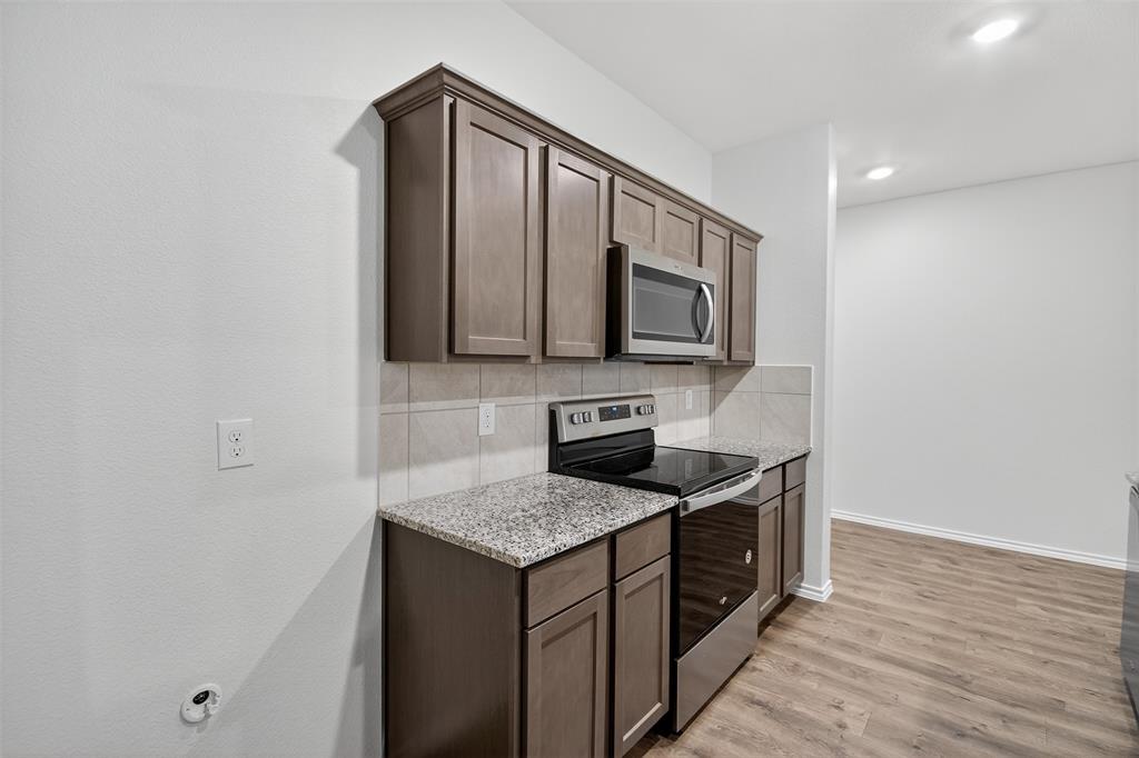 827 Rustic Way Royse City, TX 75189 - Photo 18 of 32 a kitchen with stainless steel appliances granite countertop a sink and a microwave