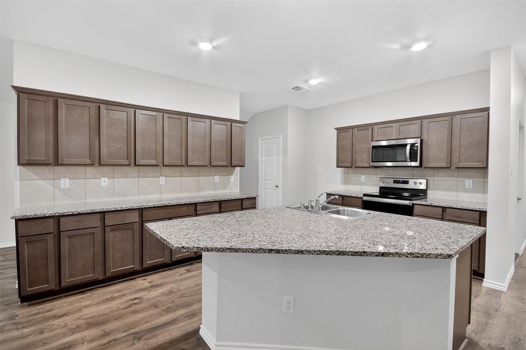 827 Rustic Way Royse City, TX 75189 - Photo 20 of 32 a kitchen with granite countertop a sink and a stove top oven
