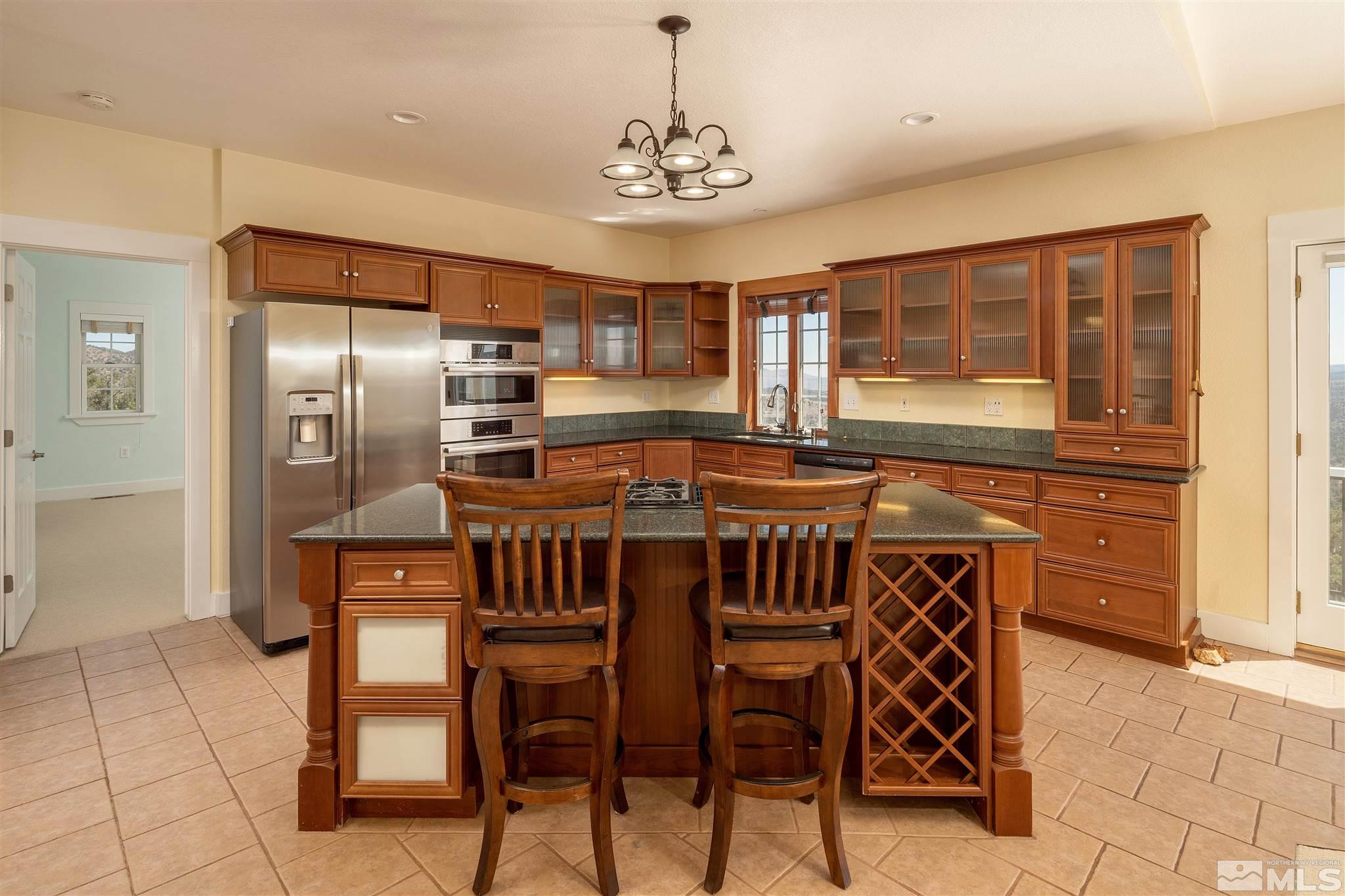 2035 Applegate Road Reno, NV 89521 - Photo 20 of 40 a kitchen with stainless steel appliances a dining table chairs and chandelier
