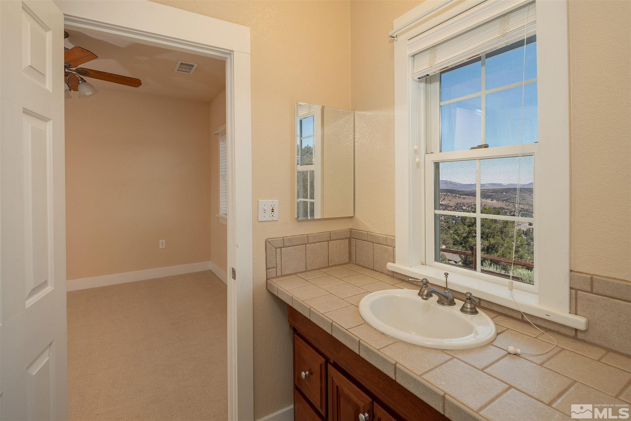 2035 Applegate Road Reno, NV 89521 - Photo 33 of 40 a bathroom with a granite countertop sink toilet and shower