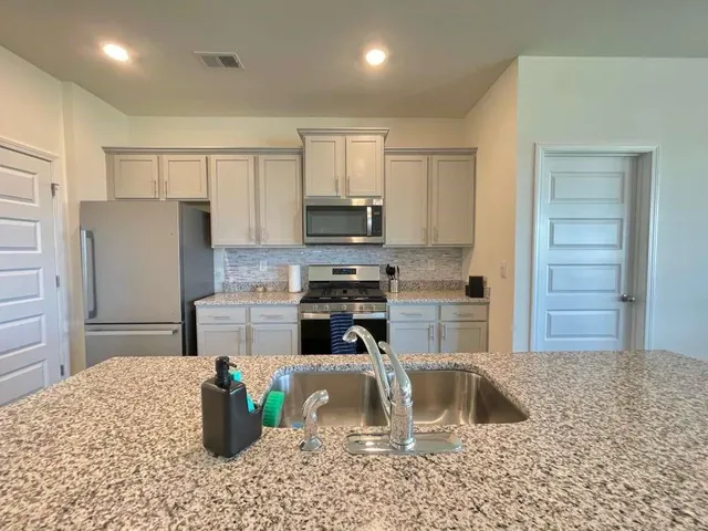 a kitchen with a refrigerator sink and cabinets