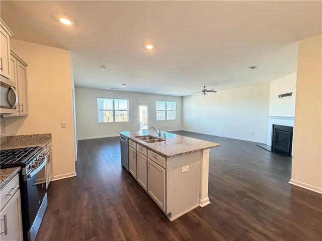 a kitchen with granite countertop a stove and a wooden floors