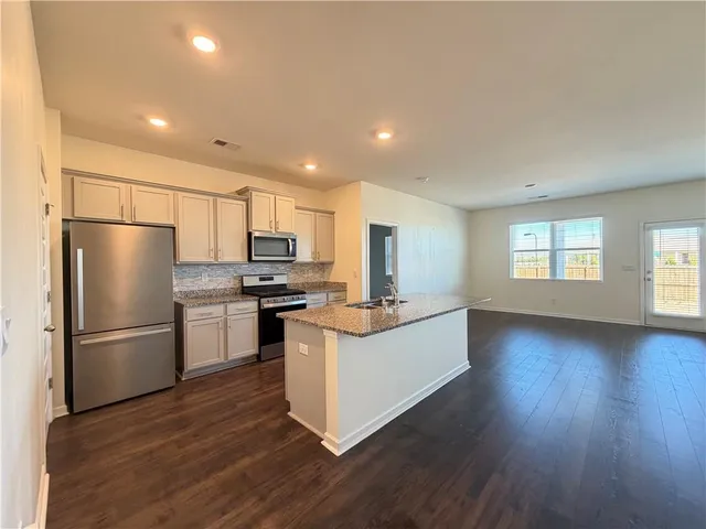 a kitchen with refrigerator cabinets and wooden floor