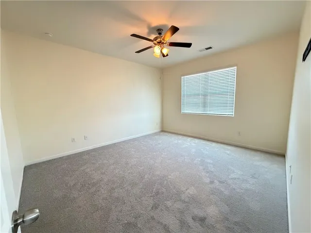 a view of a livingroom with a ceiling fan and window