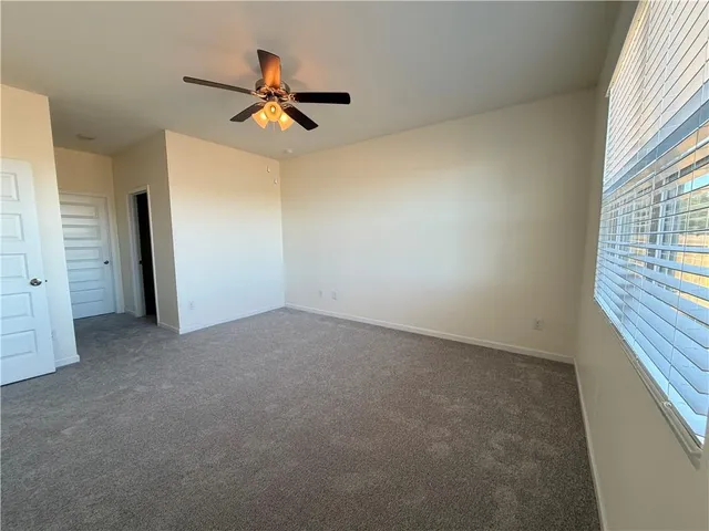 a view of empty room with ceiling fan