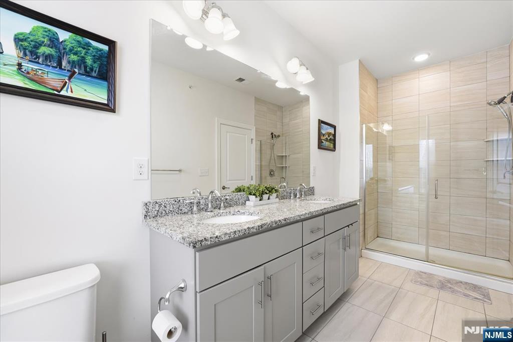 905 Abbe Road Little Falls, NJ 07424 - Photo 14 of 26 a bathroom with a granite countertop sink a mirror and a shower