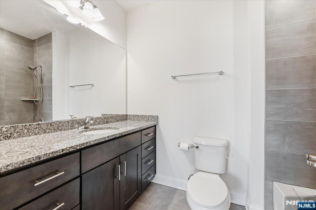 905 Abbe Road Little Falls, NJ 07424 - Photo 19 of 26 a bathroom with a granite countertop toilet sink and mirror
