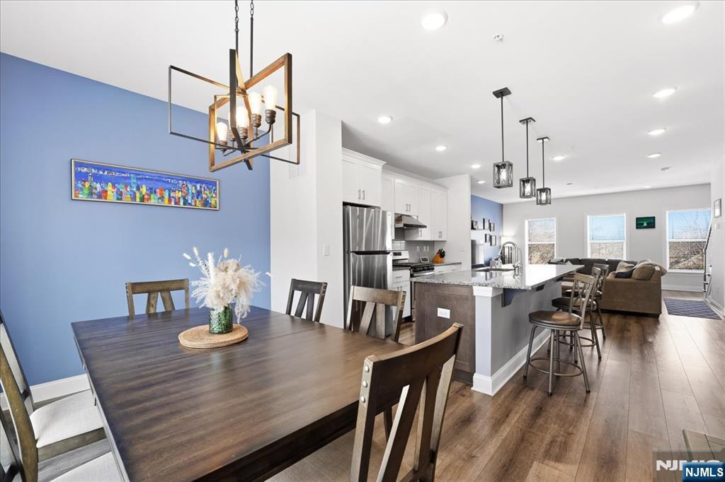 905 Abbe Road Little Falls, NJ 07424 - Photo 8 of 26 a view of a dining room and livingroom with furniture wooden floor a chandelier