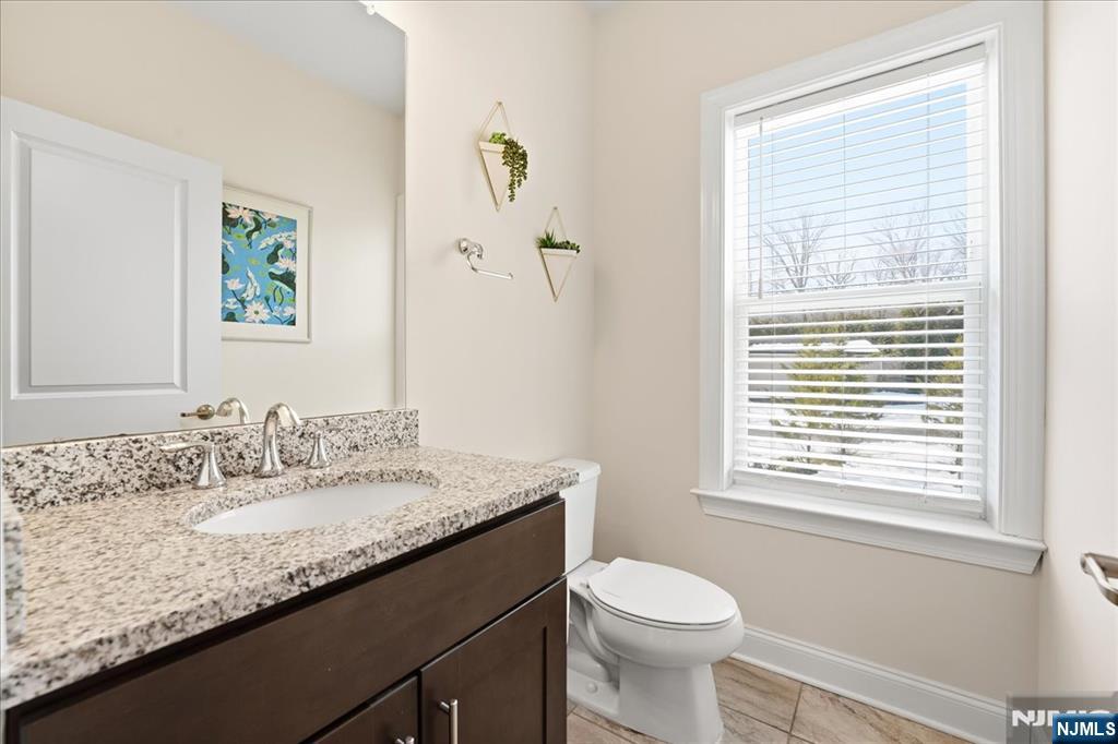 905 Abbe Road Little Falls, NJ 07424 - Photo 10 of 26 a bathroom with a granite countertop sink toilet and a window
