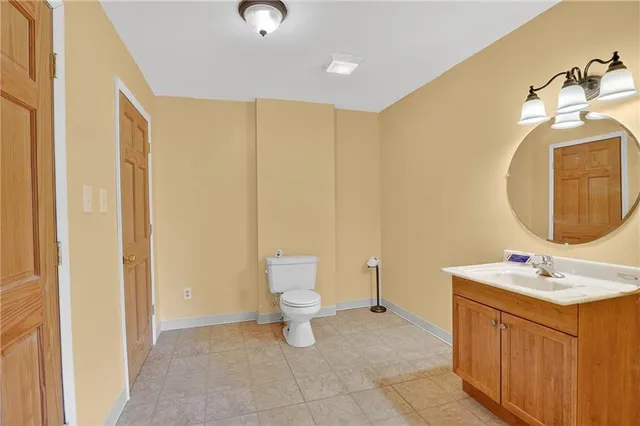 a bathroom with a sink a toilet and a mirror