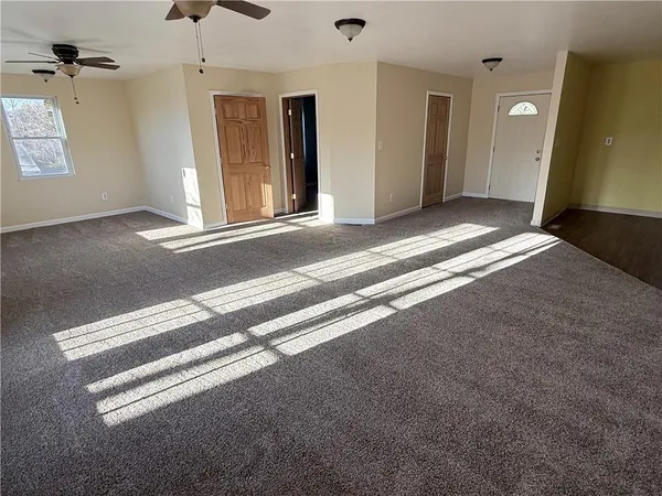 a view of a livingroom with wooden floor and a ceiling fan