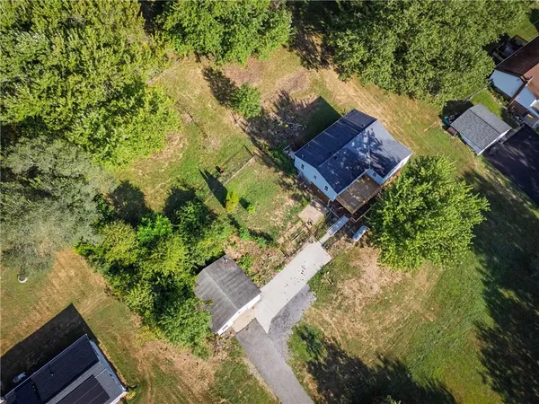 an aerial view of house with yard and mountain view in back