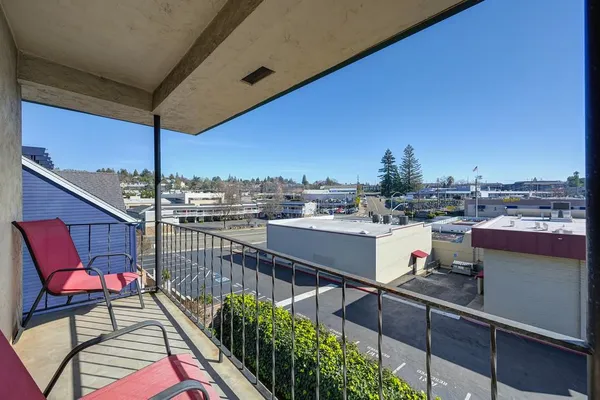 a city view from a balcony with furniture