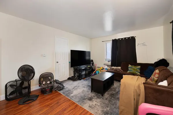 a living room with furniture a flat screen tv and a view of kitchen