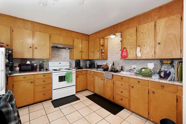 a kitchen with granite countertop cabinets and white appliances