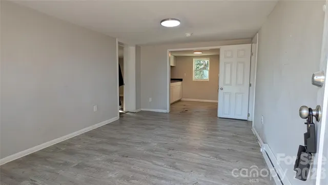 an empty room with wooden floor and a window