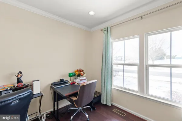 a view of a workspace with furniture and a window