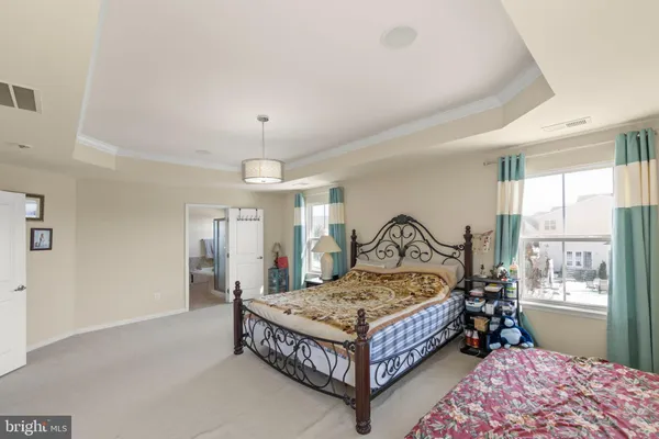 a bedroom with a bed mirror and window