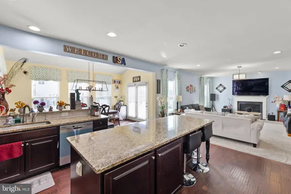 a kitchen with a stove a refrigerator and a dining table with wooden floor