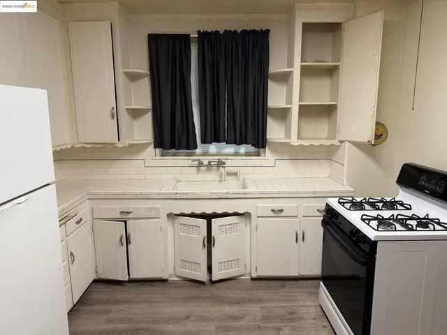 a white kitchen with a sink and a stove