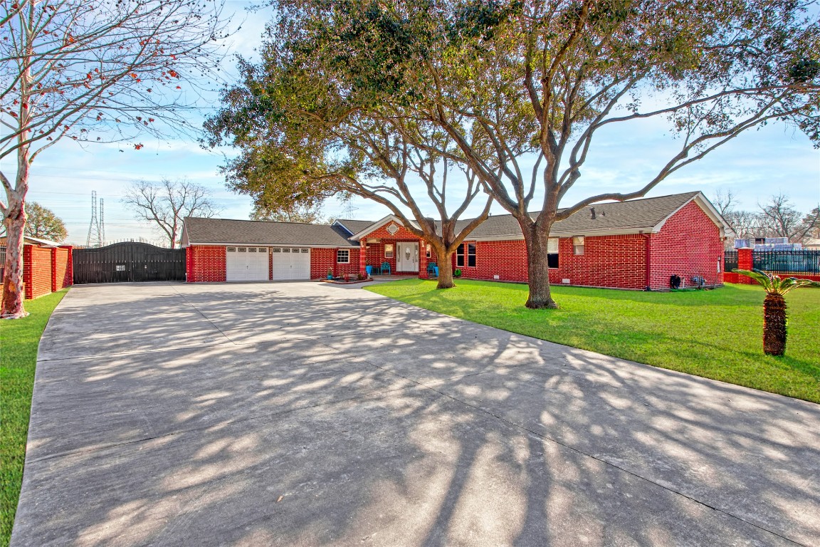 a view of house with yard and tree in front of it