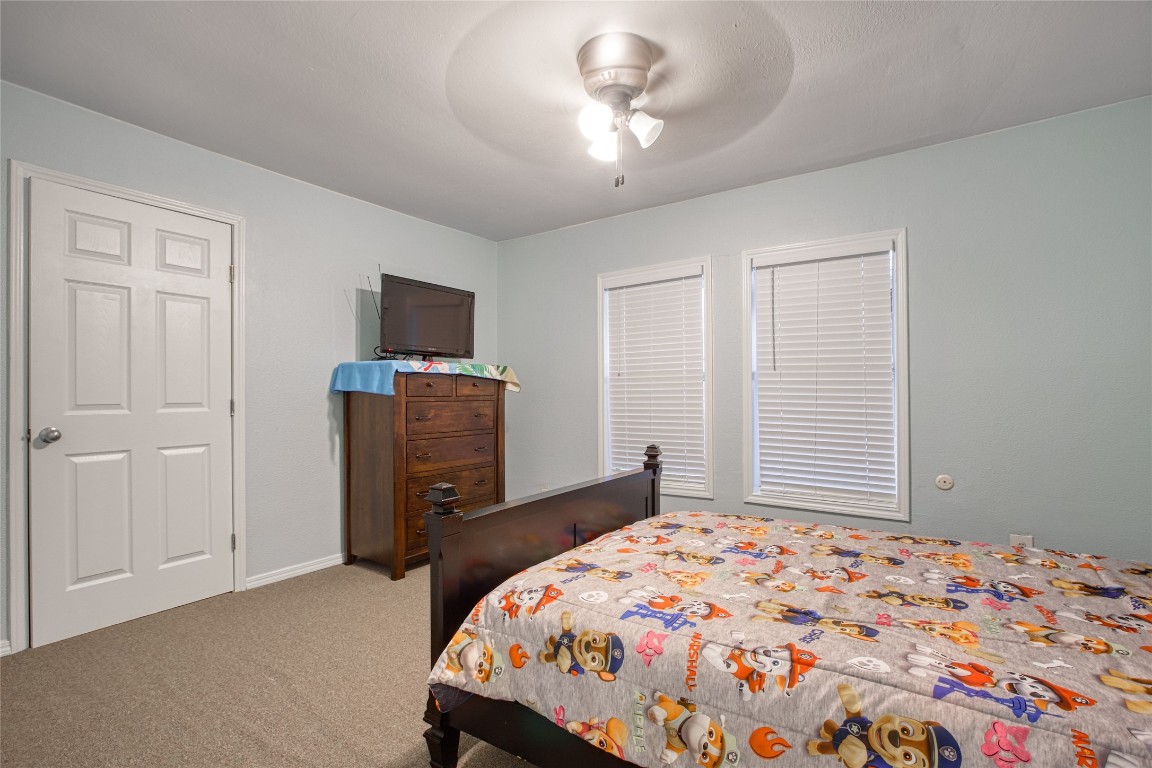 13117 Player Street Houston, TX 77045 - Photo 17 of 36 a bedroom with a bed and a flat tv screen on dresser