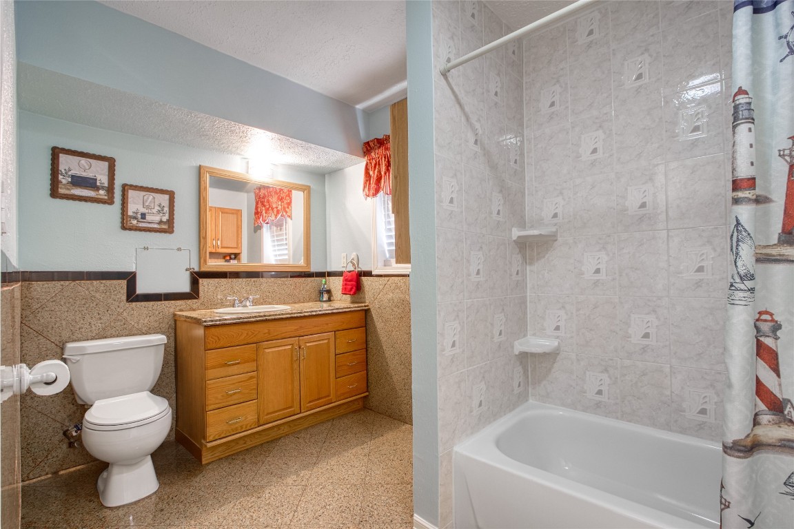 13117 Player Street Houston, TX 77045 - Photo 18 of 36 a bathroom with a granite countertop toilet a sink and a bathtub