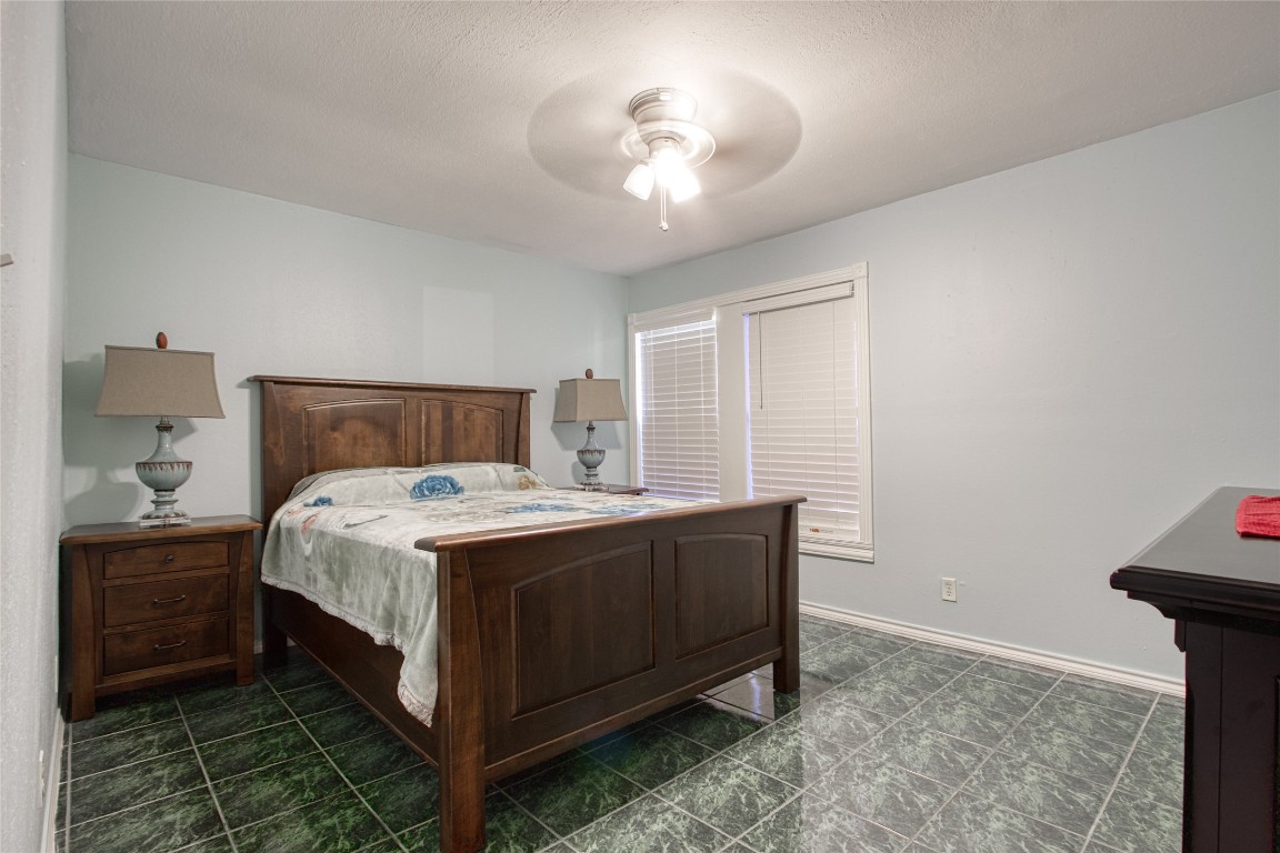 13117 Player Street Houston, TX 77045 - Photo 19 of 36 a bedroom with a bed and a chandelier