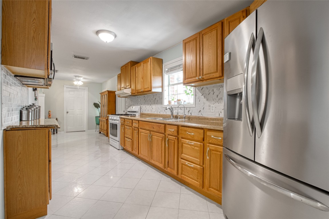 13117 Player Street Houston, TX 77045 - Photo 9 of 36 a kitchen with stainless steel appliances granite countertop a refrigerator sink and cabinets