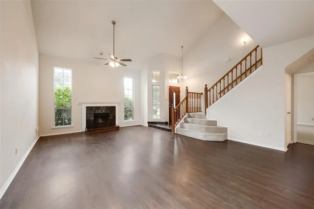 a view of a livingroom with wooden floor a fireplace and window