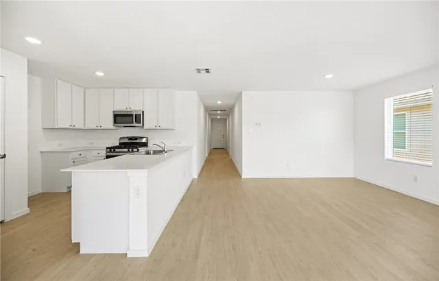 a view of a kitchen with microwave and cabinets
