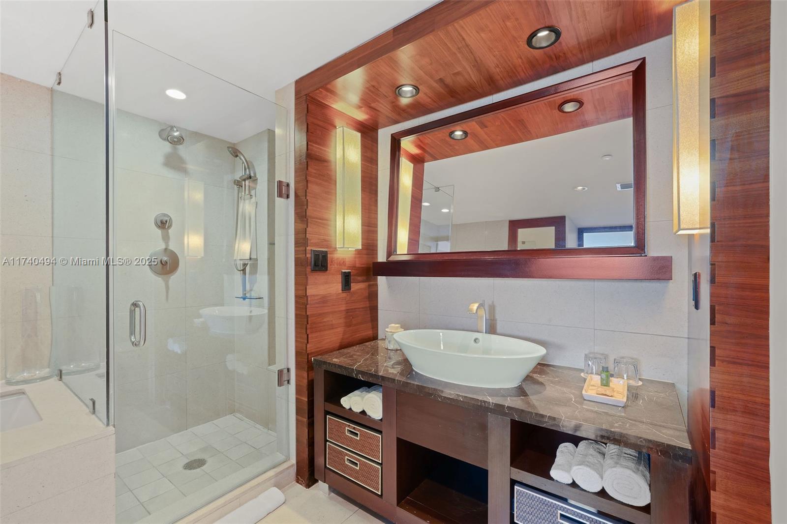 6801 Collins Avenue, Unit 608 Miami Beach, FL 33141 - Photo 21 of 24 a bathroom with a sink a mirror and a shower