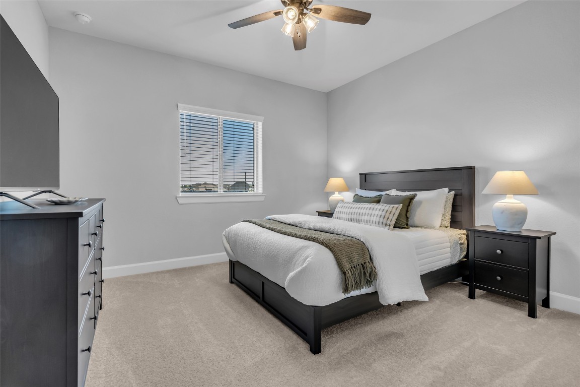 32442 Soaring Willow Way Conroe, TX 77385 - Photo 26 of 45 a bedroom with a bed and a chandelier