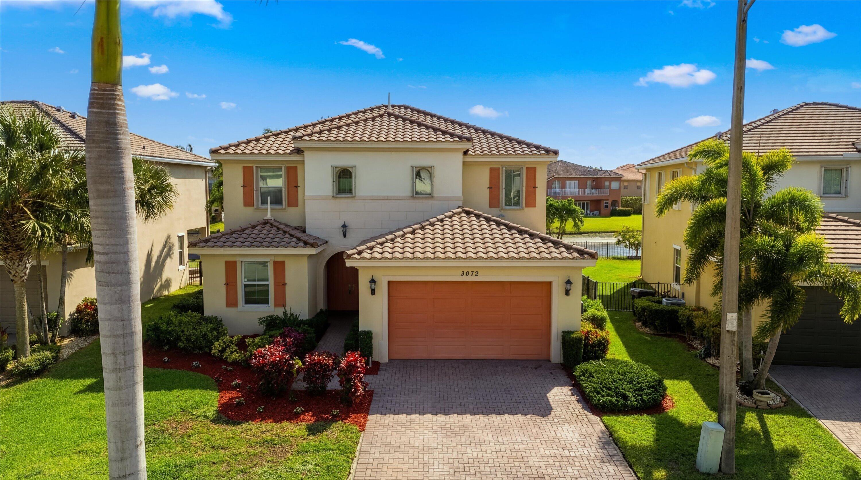3072 Payson Way Wellington, FL 33414 - Photo 43 of 43 a front view of a house with a garden