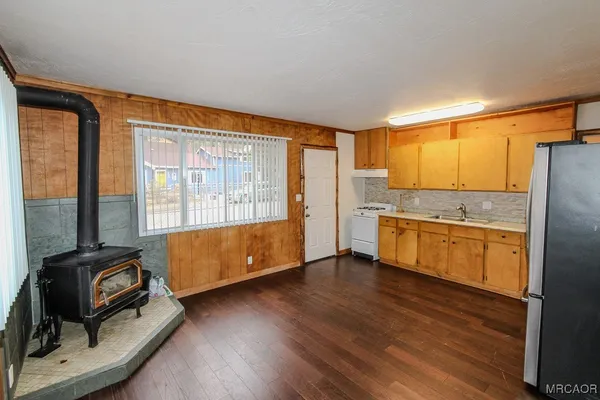 a kitchen with granite countertop a refrigerator and wooden cabinets
