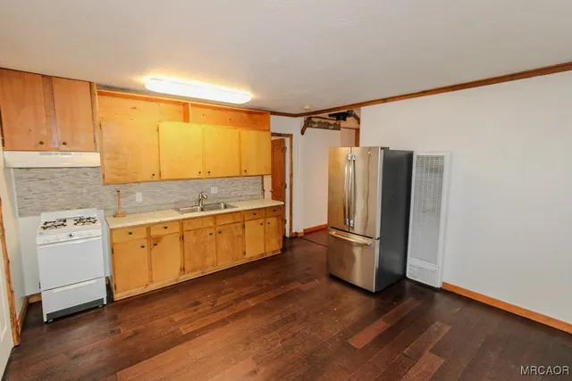 a kitchen with stainless steel appliances granite countertop a refrigerator and a stove top oven